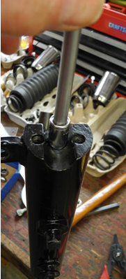 Photo showing the tapered bolt being tightened into the restrictor through the lower leg recess using a quarter-inch drive 5/16-inch socket and extension.